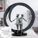 Design-Skulptur "More than Friends" - Zwei Frauen in grau/silberfarbenem Kreis auf schwarzer Base